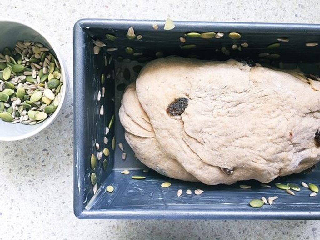 Βάλτε το ζυμάρι σε βουτυρωμένη ή λαδωμένη φόρμα, πασπαλίστε με τους σπόρους .
