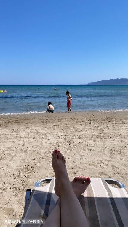 Χαλαρώνει και οι γιοι της παίζουν στην παραλία.