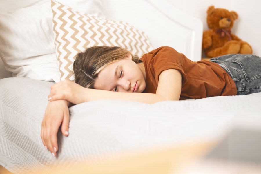 Beautiful Caucasian Teenage Girl Is Lying On Bed And Is Bored, Sad. Teenage Depression And Lonelines