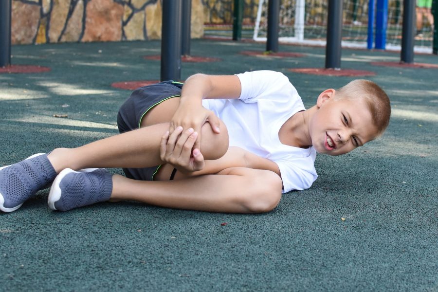 Boy Kid Banged On Gym Outside, Child Injured Limb On Playground, Sports Injury Of Boy's Leg. Young A