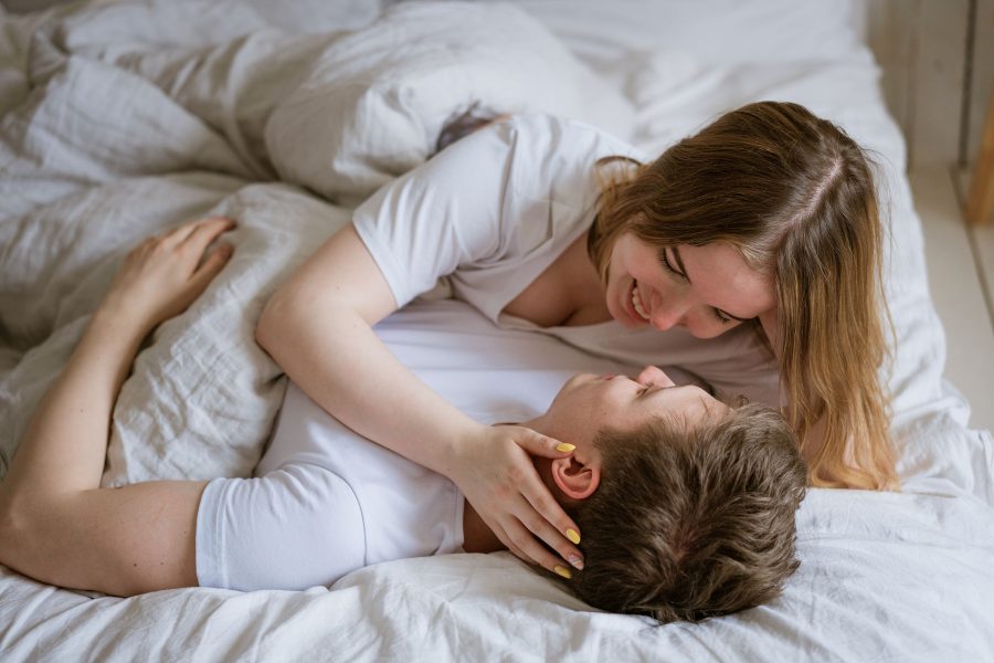 Lovely Young Caucasian Couple On White Blanket On White Bed In Room Beds, Looking Into Each Others E