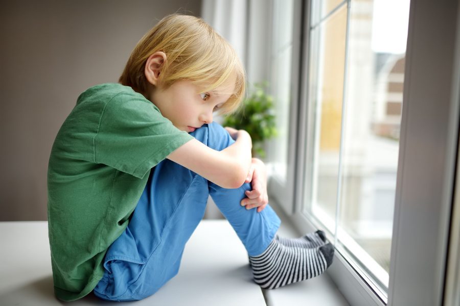 Sad Little Boy Sitting Near Window And Watching Street. Lonely At Home. No Friends, No Siblings. One